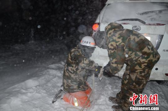 圖為消防救援人員給被困車輛安裝救援繩。　李江江 攝